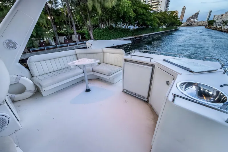 Slide: The Image of Luxurious 2003 Navigator Rival 5700 yacht deck with seating, sink, and scenic waterway view. - 24