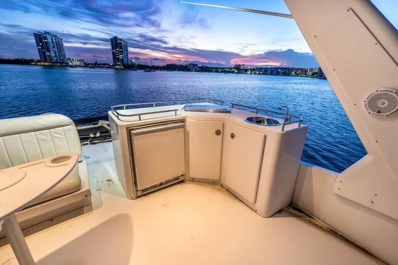 Slide: The Image of Luxury yacht deck with kitchenette, overlooking serene waterfront at sunset, Navigator Rival 5700, 2003. - 26
