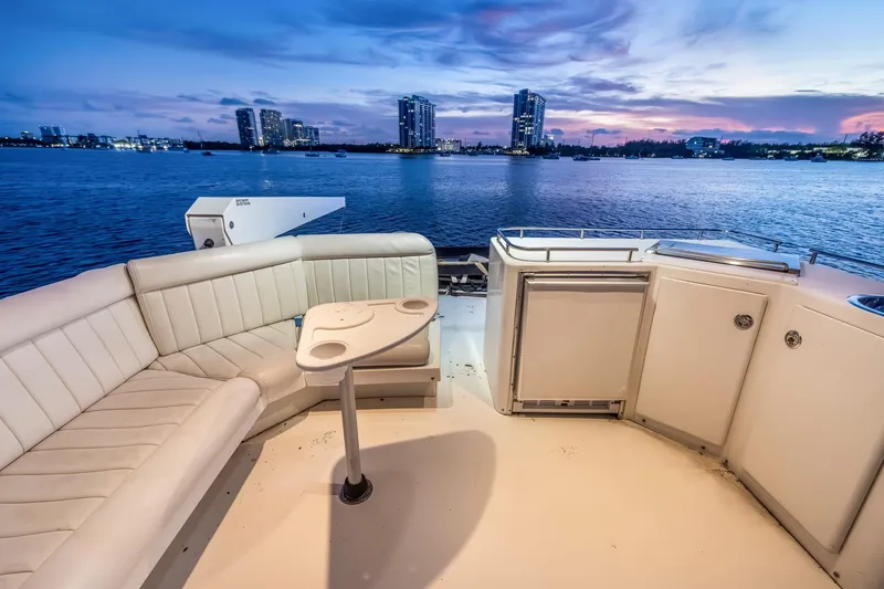 Slide: The Image of Luxurious 2003 Navigator Rival 5700 yacht deck with seating, overlooking serene waterfront cityscape. - 27
