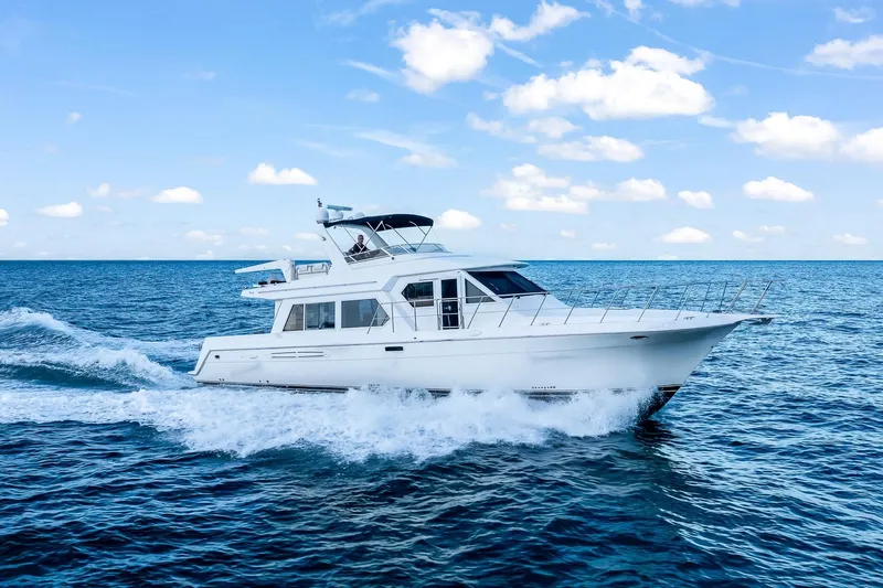 Slide: The Image of 2003 Navigator Rival 5700 yacht cruising on open sea under blue sky. - 3