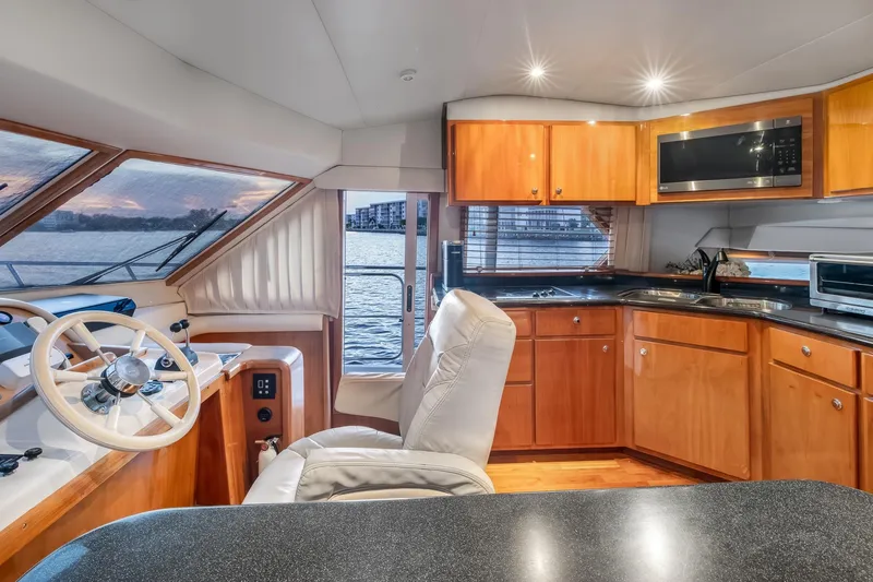 Slide: The Image of Luxurious 2003 Navigator Rival 5700 yacht interior with helm, kitchen, and waterfront view. - 35