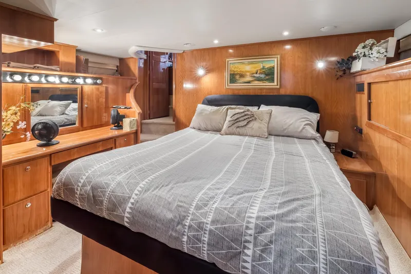 Slide: The Image of Luxurious 2003 Navigator Rival 5700 yacht bedroom with elegant wood paneling and cozy bedding. - 43