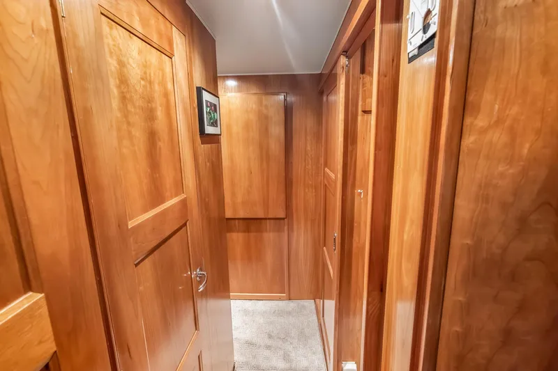 Slide: The Image of Wood-paneled hallway inside 2003 Navigator Rival 5700 yacht, featuring elegant doors and soft lighting. - 48