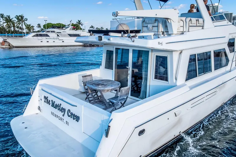 Slide: The Image of 2003 Navigator Rival 5700 yacht cruising on blue waters near palm trees. - 6