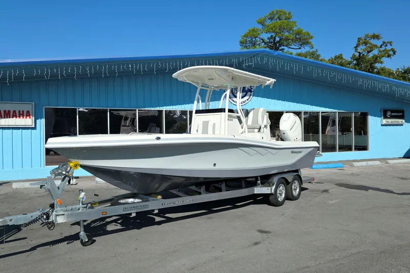 The Image of 2026 Ranger 2600 Bay boat on trailer outside dealership, palm trees in background. - 0