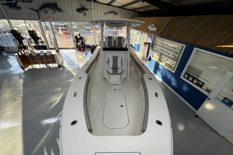 Slide: The Image of 2026 Ranger 2600 Bay boat displayed in a showroom with fishing decor. - 11