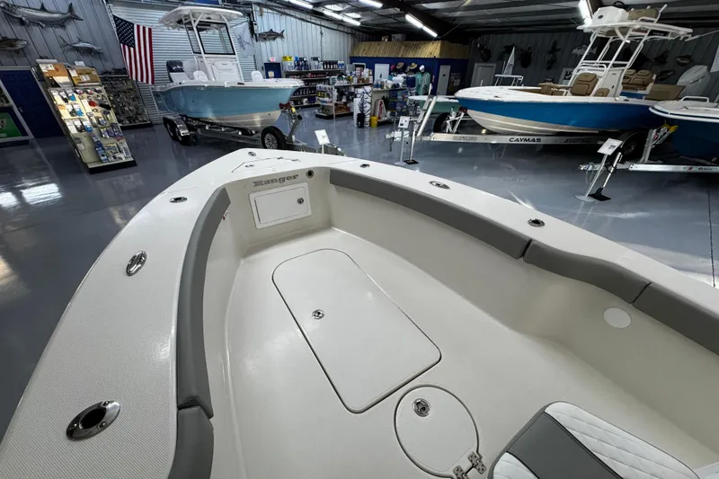 Slide: The Image of 2026 Ranger 2600 Bay boat displayed in a showroom with other boats and accessories. - 13