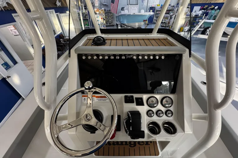 Slide: The Image of 2026 Ranger 2600 Bay boat dashboard with steering wheel and control panel in showroom. - 18