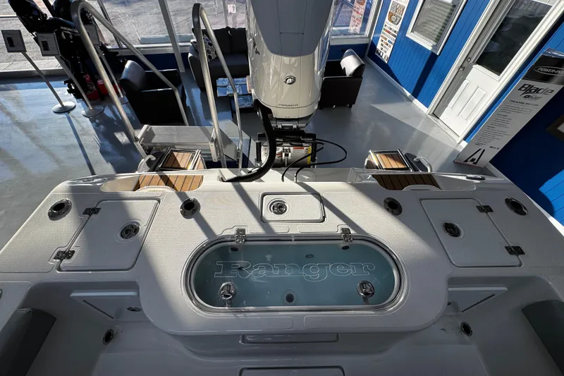 Slide: The Image of 2026 Ranger 2600 Bay boat interior with engine and seating in showroom. - 21