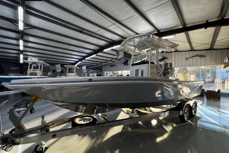 Slide: The Image of 2026 Ranger 2600 Bay boat on trailer in a spacious indoor showroom. - 4