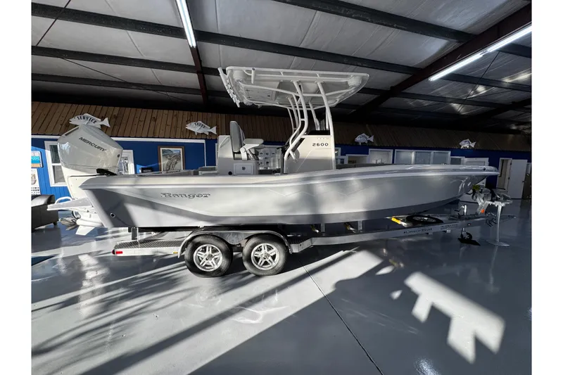 Slide: The Image of 2026 Ranger 2600 Bay boat on trailer in showroom, featuring sleek design and modern features. - 7