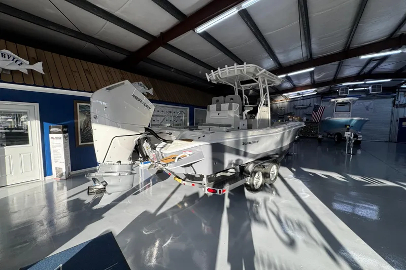 Slide: The Image of 2026 Ranger 2600 Bay boat in showroom, featuring a powerful outboard motor. - 8