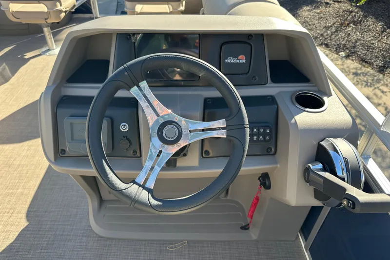 Slide: The Image of 2025 Sun Tracker Fishin' Barge 20 DLX steering console with controls and cup holder. - 6