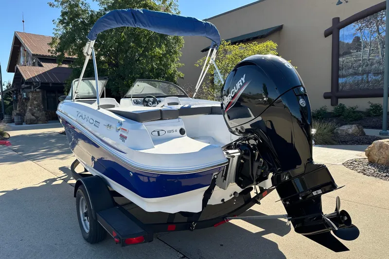 Slide: The Image of 2024 Tahoe 185 S boat with Mercury engine on trailer, parked outdoors. - 2