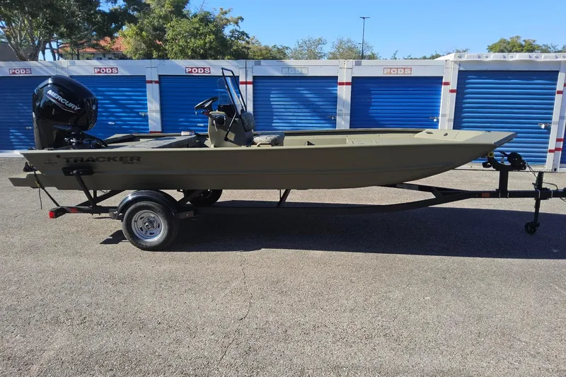 The Image of 2026 Tracker Grizzly 1860 CC boat on trailer, parked near storage units. - 0