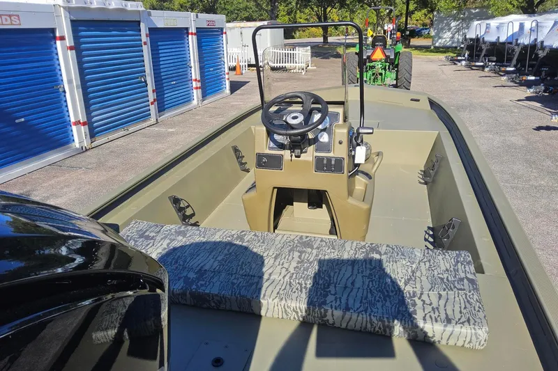 Slide: The Image of 2026 Tracker Grizzly 1860 CC boat interior with steering console and patterned seating. - 2