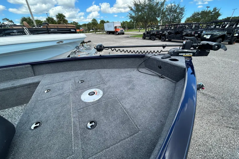 Slide: The Image of 2026 Tracker Pro Guide V-16 SC boat with Minn Kota trolling motor, parked outdoors. - 3