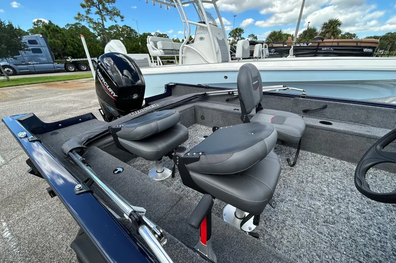 Slide: The Image of 2026 Tracker Pro Guide V-16 SC boat interior with seating and Mercury outboard motor. - 6