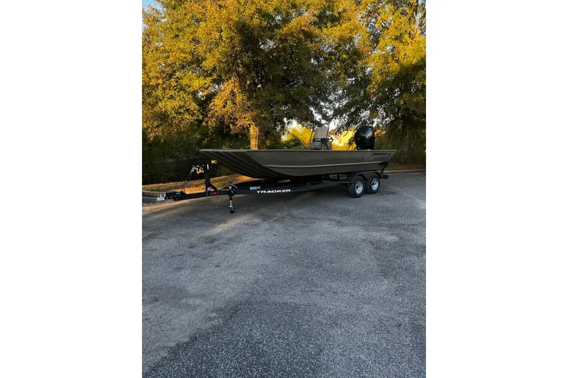 The Image of 2026 Tracker Grizzly 2072 CC boat on trailer, parked outdoors with trees in background. - 0