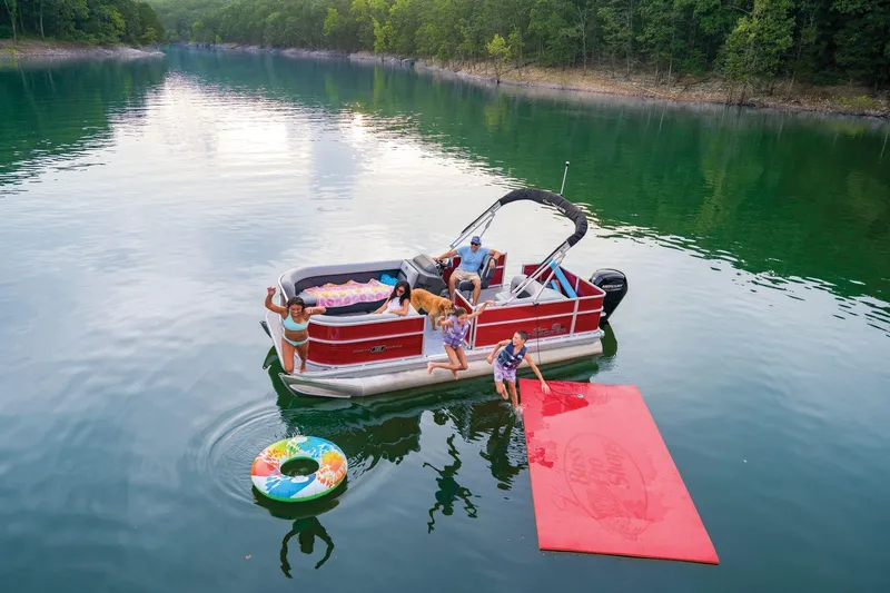 Slide: The Image of 2026 Sun Tracker Party Barge 18 DLX pontoon boat with Mercury engine, parked outdoors. - 2