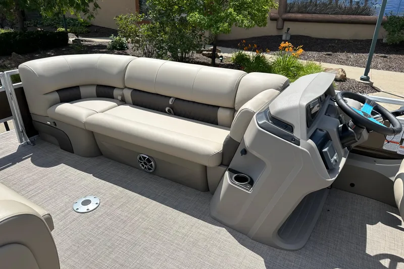 Slide: The Image of 2025 Sun Tracker SportFish 22 DLX boat interior with beige seating and steering console. - 5