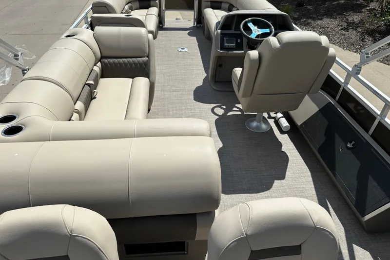 Slide: The Image of 2025 Sun Tracker SportFish 22 DLX pontoon boat interior with beige seating and steering console. - 8