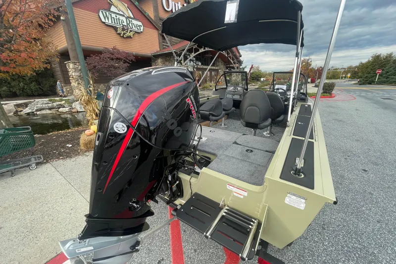 Slide: The Image of 2026 Tracker Targa V-19 Combo boat with powerful outboard motor, parked near White River Fly Shop. - 2