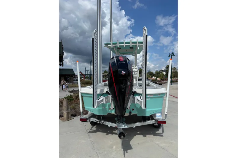 Slide: The Image of 2026 Mako 24 APEX boat with outboard motor, parked on a sunny day. - 3