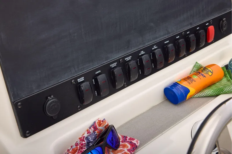 Slide: The Image of Secure storage compartment on 2026 Mako 24 APEX boat with strap and latch. - 32