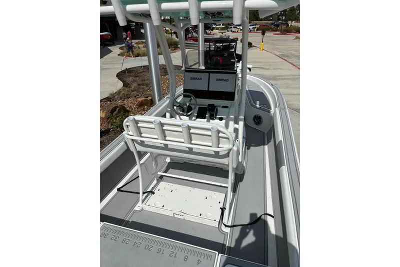 Slide: The Image of 2026 Mako 24 APEX boat interior with steering console and rod holders. - 4