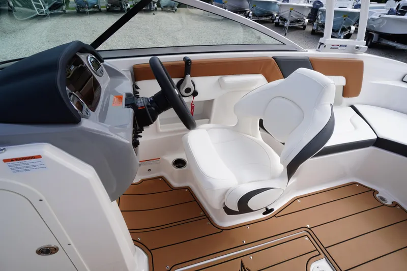 Slide: The Image of 2023 Chaparral 23 SSi OB boat interior with white captain's seat and modern dashboard. - 17