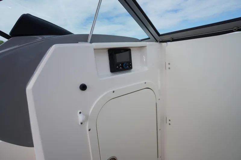 Slide: The Image of 2023 Chaparral 23 SSi OB boat interior with control panel and storage compartment. - 21