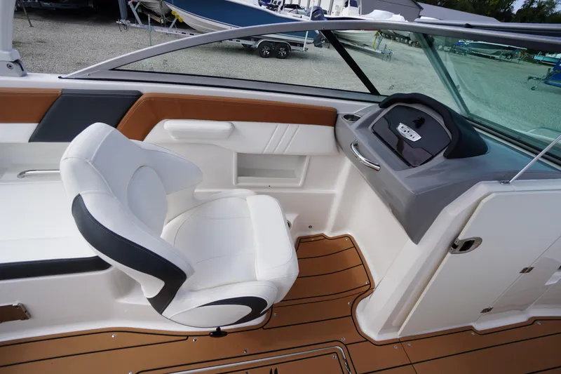 Slide: The Image of 2023 Chaparral 23 SSi OB boat interior with white seating and modern dashboard. - 24