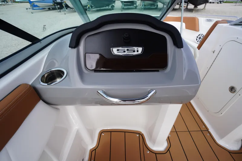 Slide: The Image of 2023 Chaparral 23 SSi OB boat dashboard with cup holder and storage compartment. - 25