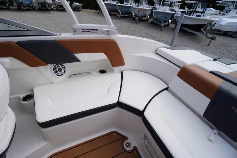 Slide: The Image of 2023 Chaparral 23 SSi OB boat interior with white and brown seating, speaker, and cup holder. - 28
