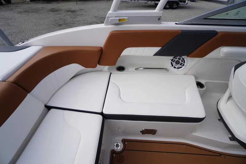 Slide: The Image of 2023 Chaparral 23 SSi OB boat interior with brown and white seating, speaker, and cup holders. - 29