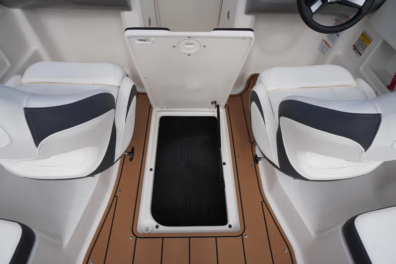 Slide: The Image of 2023 Chaparral 23 SSi OB boat interior with open storage compartment and cushioned seats. - 33