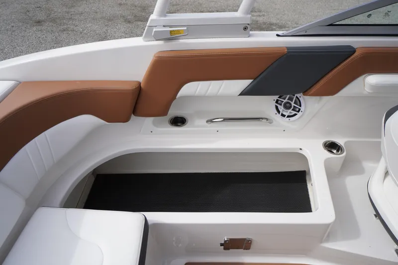 Slide: The Image of 2023 Chaparral 23 SSi OB boat interior with brown and black seating, storage, and speaker. - 36