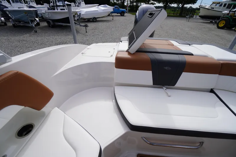 Slide: The Image of 2023 Chaparral 23 SSi OB boat interior with cushioned seating and storage compartment. - 40