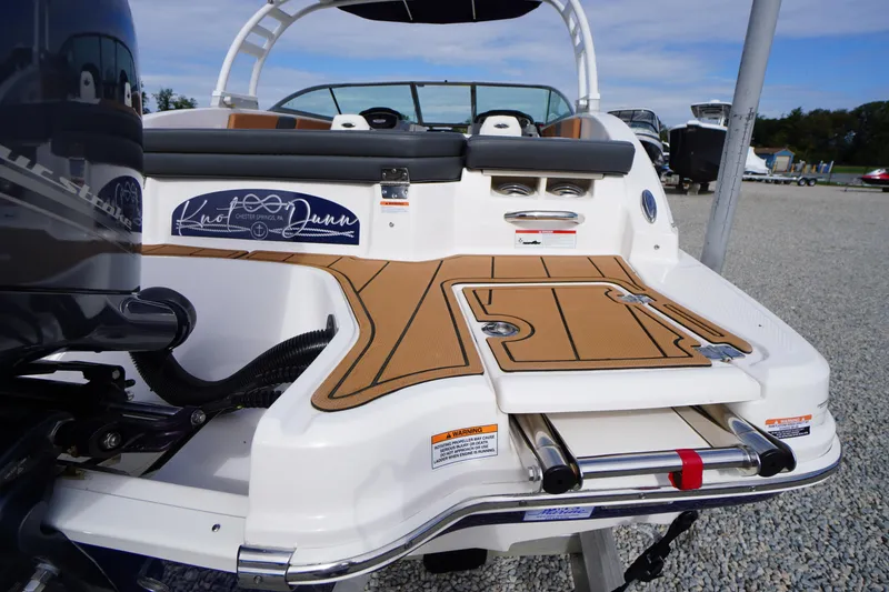 Slide: The Image of 2023 Chaparral 23 SSi OB boat with swim platform and ladder, displayed outdoors. - 50