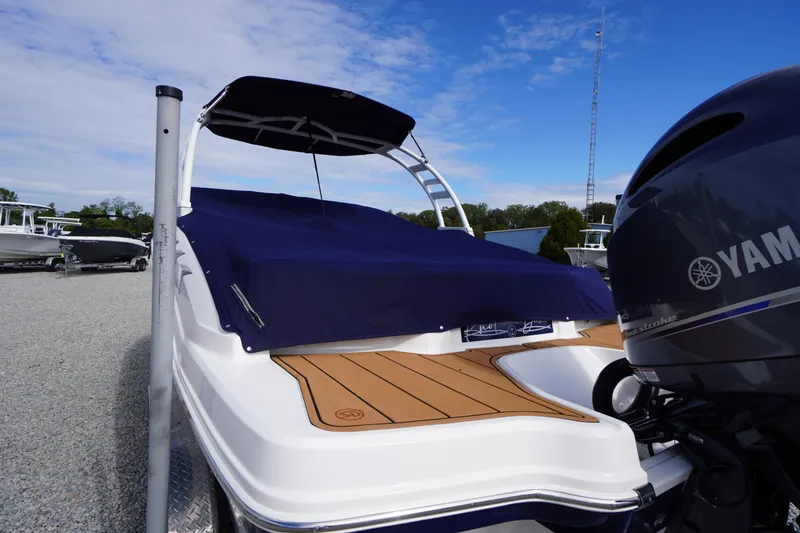 Slide: The Image of 2023 Chaparral 23 SSi OB boat with Yamaha engine, covered deck, and blue canopy. - 52