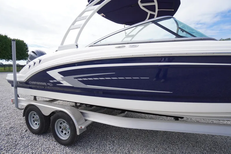Slide: The Image of 2023 Chaparral 23 SSi OB boat on trailer, featuring sleek blue and white design. - 58