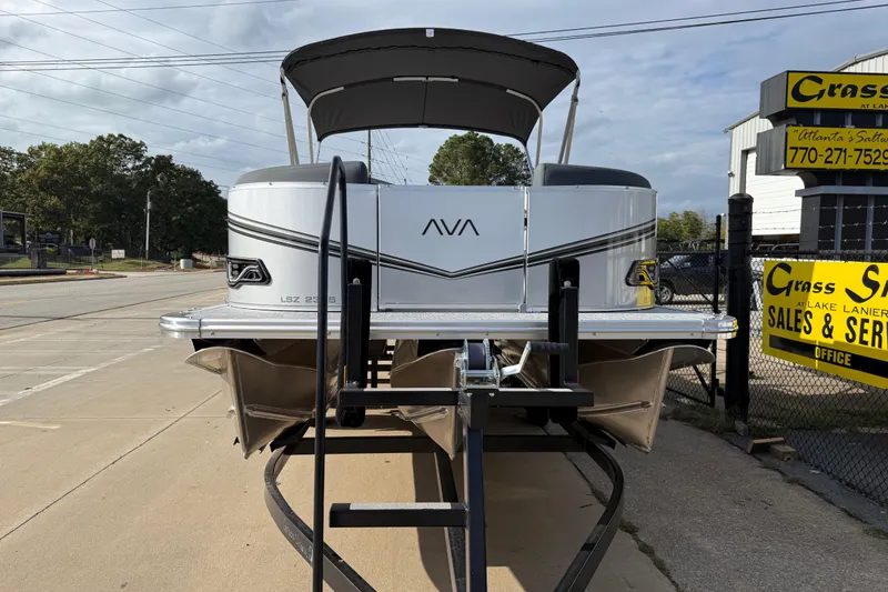Slide: The Image of 2026 Avalon LSZ Quad Lounger Shift pontoon boat at dealership, front view. - 1