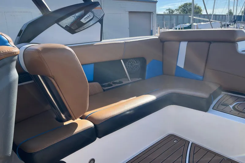Slide: The Image of 2016 Nautique Super Air Nautique 230 interior with brown and blue seating. - 12