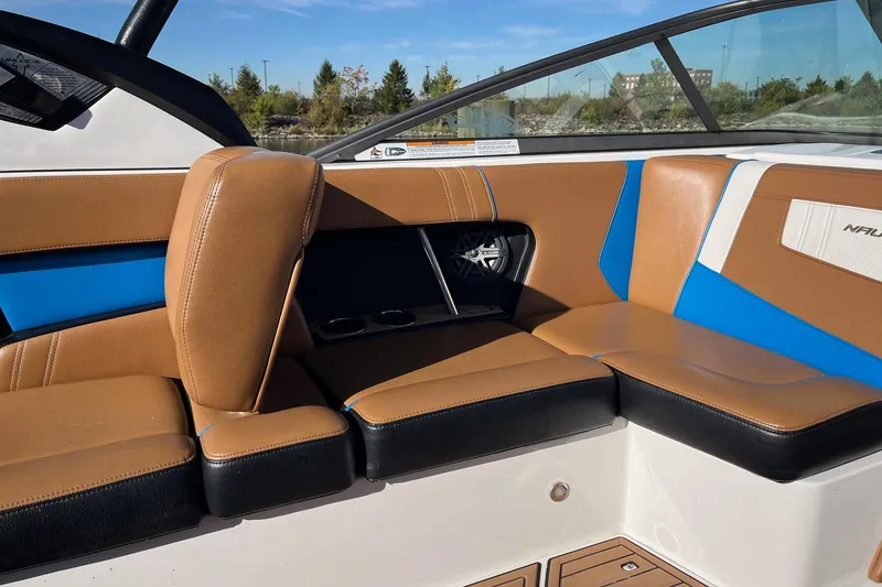 Slide: The Image of 2016 Nautique Super Air Nautique 230 interior with tan and blue seating. - 8