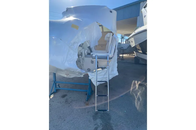 Slide: The Image of 2026 Grady-White Freedom 325 boat, partially covered, with a ladder in a marina. - 14