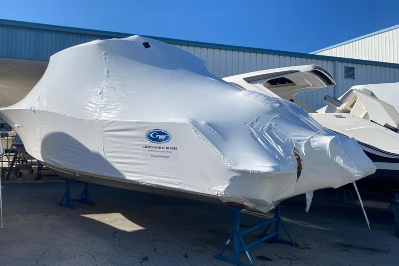 Slide: The Image of 2026 Grady-White Freedom 325 boat covered in protective wrap at a marina. - 2