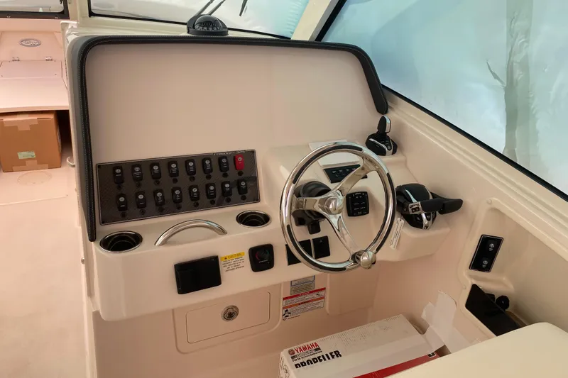 Slide: The Image of 2026 Grady-White Freedom 325 boat helm with steering wheel and control panel. - 7