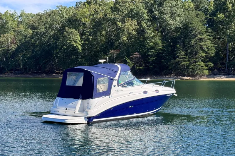 Slide: The Image of 2005 Sea Ray 280 Sundancer boat on a serene lake with forested background. - 10