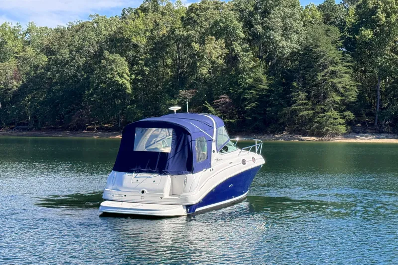 Slide: The Image of 2005 Sea Ray 280 Sundancer boat on a serene lake with forested shoreline. - 11